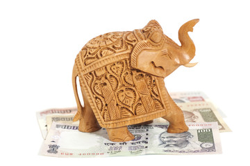 Wooden elephant sculpture on Indian  Rupee banknotes
