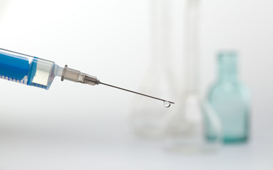 a syringe with a drop on the end of the needle