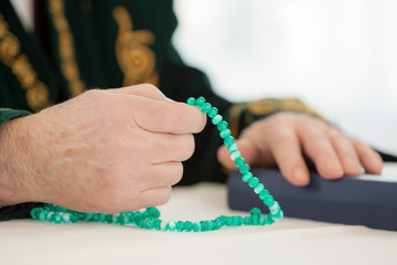 Hand of an old mullah holding rosary beads
