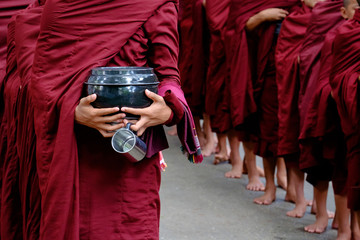 Detail of buddhist monks crowd and person holding a bowl and cup