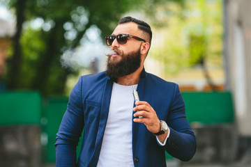 man with a beard smokes electronic cigarette
