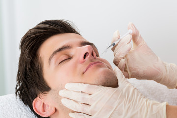 Close-up Doctor Giving Injection in Man's Face
