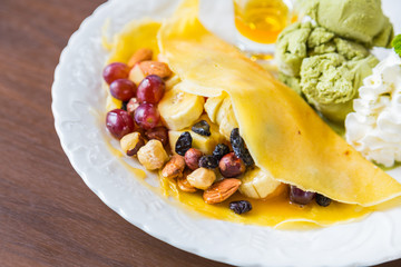 Pancake and fruit with ice cream on table
