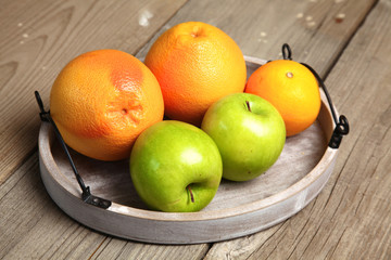 Apples and oranges on old wooden background