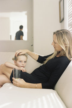 Mother and daughter relaxing on sofa