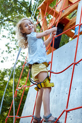 Little girl in  rock climbing gym