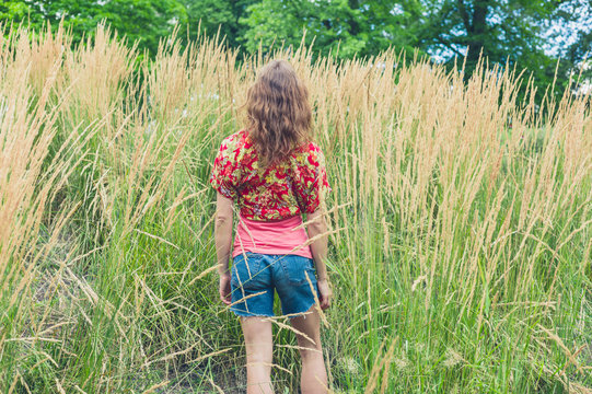 Young woman standing in tall grass