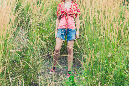 Young woman standing in tall grass