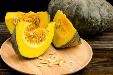 Raw pumpkin on wooden plate