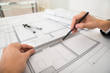 Engineer Drawing Diagrams On Blueprint Paper