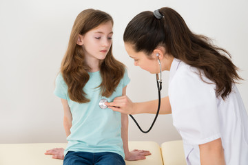 Doctor Examining Girl In Hospital