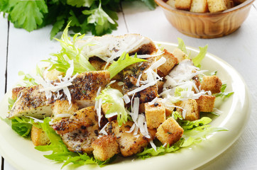 Caesar chicken salad on white table