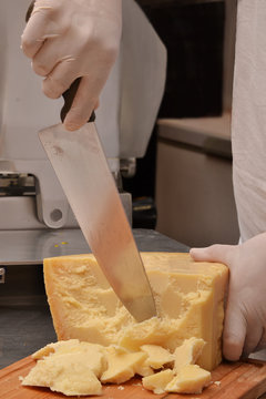 Cortando trozos de queso parmesano.