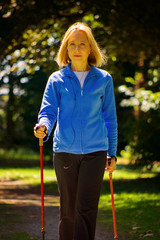 Sportliche Seniorin beim Nordic Walking