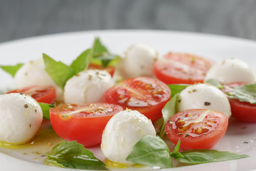 caprese salad with mini mozzarella balls and tomatoes