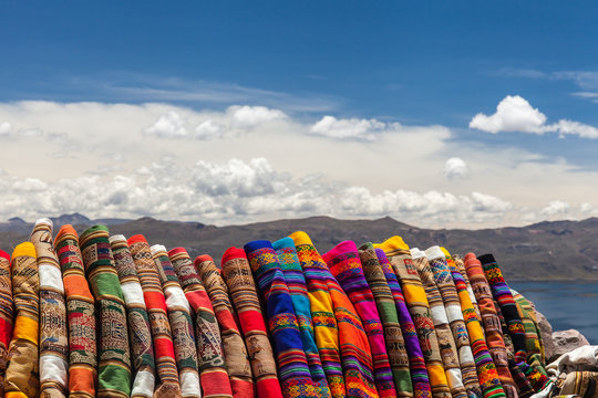 Tessuti tipici colorati del Sud America. Peru e Bolivia. Lago e montagne con nuvole bianche sullo sfondo