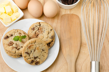Homemade chocolate cookies on the white plate and wooden background