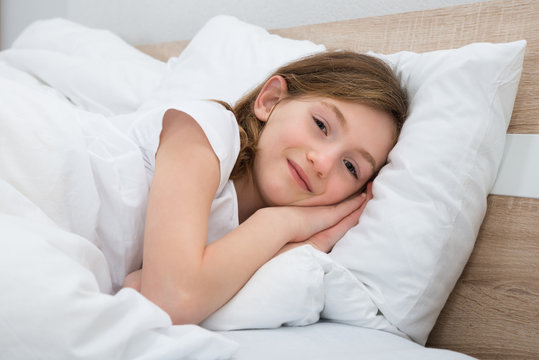 Happy Girl Lying In Bed