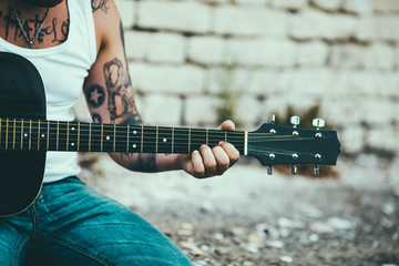 Man with tattoes playing guitar