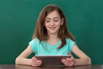 Girl With Digital Tablet Sitting At Desk