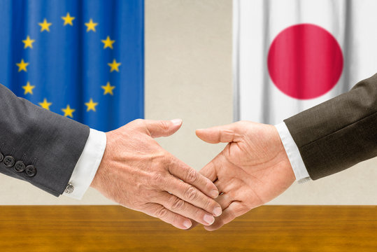 Vertreter der EU und Japans reichen sich die Hand
