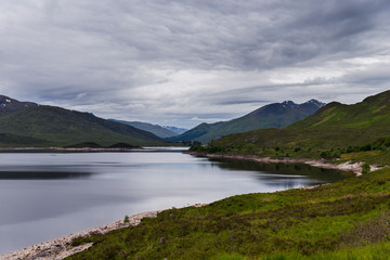 Fototapeta na wymiar Lake and mountains in cloudy day, Scotland landscape