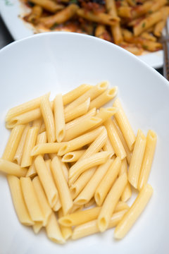 raw penne pasta in bowl