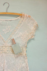 vintage white crochet lace top with hanger on wooden background
