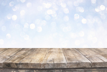 rustic wood table in front of glitter silver and gold bright lights
