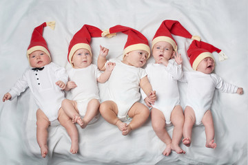 babies with santa hats on bright background