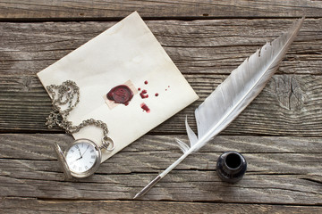 Wax sealed letter with quill on wooden background