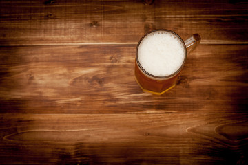 A glass of beer on the background of the wooden planks.