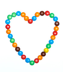 heart frame of colorful candy on a white background with space f