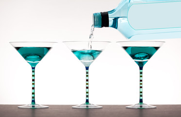 liquor being poured into martini glasses