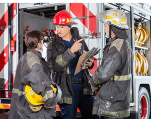 Fototapeta premium Firefighter Discussing With Colleagues At Fire Station