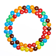round frame of colorful candy on a white background with space f