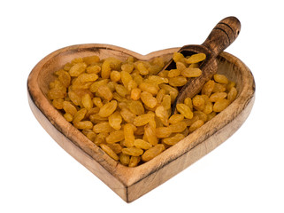 Yellow raisins in the wooden bowl isolated.