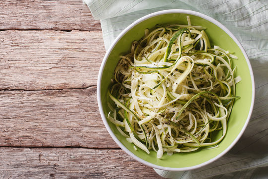 Useful raw zucchini pasta in a bowl close up. horizontal top view
