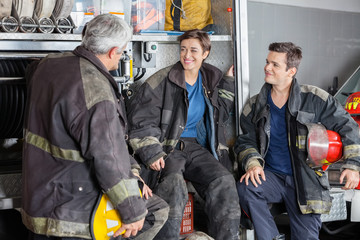 Obraz premium Happy Firefighters Conversing By Firetruck