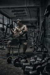 Fototapeta na wymiar Athlete in old rusty gym