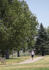 Mature female taking her daily walk in a park outdoors.
