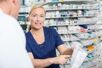 Female Pharmacist Explaining Details Of Product To Customer