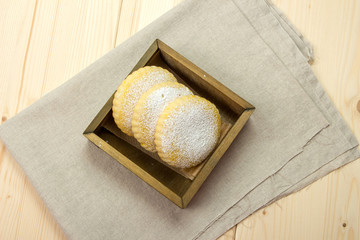 Homemade biscuits milk with powdered sugar in a wooden box
