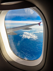 Naklejka premium Clouds and sky as seen through window of an aircraft