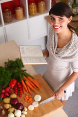 Young woman cutting vegetables in the kitchen