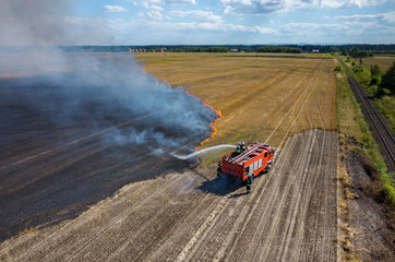 Fototapeta premium Fireman truck working on the field on fire