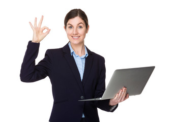 Businesswoman hold with laptop computer and ok sign gesture