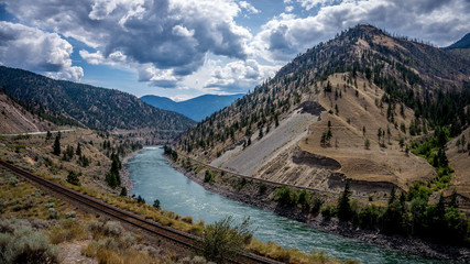 The Fraser River as it winds its way through the Fraser Canyon to the Pacific Ocean. The canyon is an important corridor for both rail and truck/car traffic to the west coast - obrazy, fototapety, plakaty