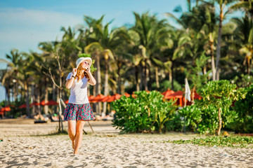 Beautiful young caucasian woman at the beach in white hat