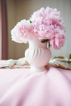 Pink Peonies in a ceramic vase in natural light.